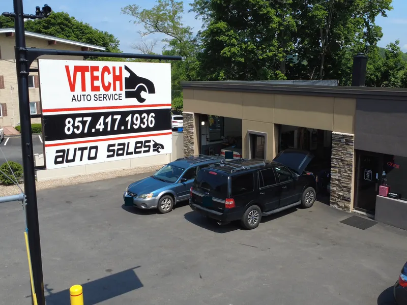 V-Tech Auto Services shop with its roadside sign and garage bays, seen from a drone