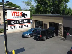 V-Tech Auto Services shop with its roadside sign and garage bays, seen from a drone